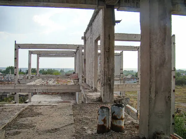 Harap olmuş beton bir yapının görüntüsü, kısmen çökmüş, kırsal ya da endüstriyel alanda bitkisel büyüme ve yıpranma belirtileri gösteriyor.