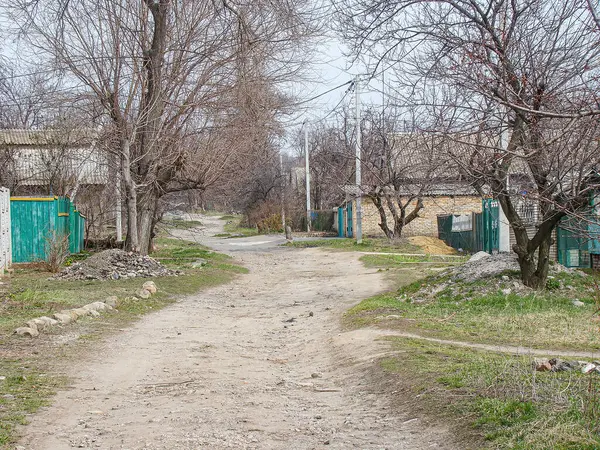 Ağaçlar ve mütevazı evlerle çevrili sakin, kırsal bir manzara serin bir hava sunuyor.