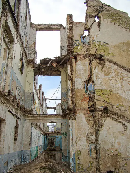 Yapısal hasarı olan terk edilmiş ya da yıkık dökük bir bina. İçi beton ve metal kirişler sergileniyor. Ürkütücü, ıssız bir atmosfer yaratıyor.