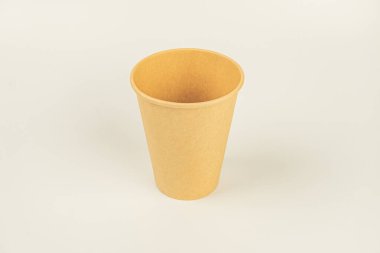 Düz bir yüzey üzerinde tek seferlik açık kahverengi kahve fincanı içeren minimalist bir görüntü.