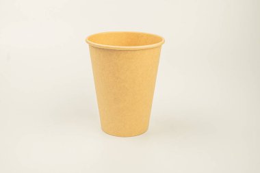 Açık gri arkaplana karşı canlı bir sarı seramik ya da terracotta bardağı, potansiyel pazarlama kullanımı için renk ve dokusunu vurgulayan basitlik