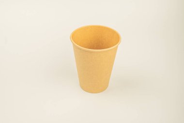 Tek kullanımlık sarımsı plastik bardak, tek kullanımlık plastiklere alternatif çevre dostu reklamlar için potansiyel olarak kullanılan düz bir yüzeyde bulunur.