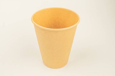 Dışı pürüzsüz ve parlak bir iç yapısı olan bej renkli bir içecek bardağı, görsel olarak çekici bir ürün çekiminde nötr gri bir arkaplan karşısında sergileniyor.