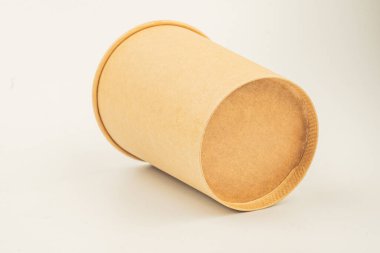 Resim, sandviç, salata veya ambalaj gibi yiyecek maddeleri için potansiyel olarak kullanılan, paket servisi veya dağıtım amaçlı, çevre dostu, minimalist bir kağıt kap sergiliyor