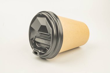 Düz bir yüzeye yerleştirilmiş, sıcak içecekler için uygun, yeniden mühürlenebilir kapağı olan tek porsiyon bir kahve fincanı.