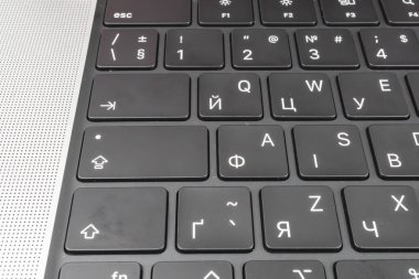 Bir QWERTY dizüstü dizüstü bilgisayar klavyesinin yakın plan resmi, açık okunabilirlik, dayanıklılık ve kullanılabilirlik öneren siyah arkaplan üzerinde beyaz tuşlar gösterilir