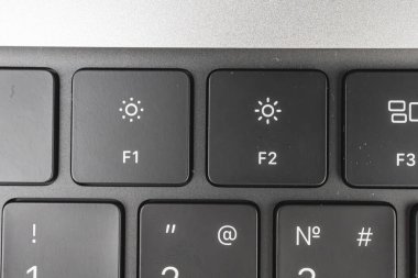 Güneş amblemli F1 'den F3' e odaklanan bir dizüstü bilgisayarın klavyesinin yakın plan görüntüsü, parlaklık denetimlerinin kenarlarda hafifçe bulanıklaştığını gösteriyor
