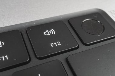 Hacim tuşlarına odaklanmış bir bilgisayar klavyesinin yakın plan görüntüsü, özellikle ses düzeyi yukarı tuşu, kullanım veya seçimini vurguluyor