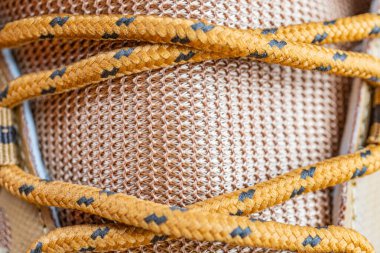 Kontrastlı dikişli, güvenli bağcıklı ve tasarım ve işçiliğe odaklı bir spor ayakkabısının yakın plan görüntüsü.