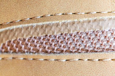 Karmaşık bir şekilde dikilmiş yüksek kaliteli deri kumaşın yakın plan görüntüsü, lüks pazarlara hitap eden...