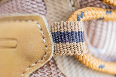 Örülmüş bileziklerin yakın plan bir görüntüsü, karmaşık desenler ve zıt gölgeler üzerine odaklanarak, kumaş dokusu ve zanaatkarlığı sergiliyor.