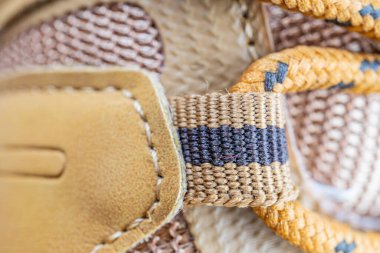 El yapımı, sarı ve mavi dokuma kemer ve açık kahverengi deri çanta ya da bagaj etrafına bağlanmış kültürel desenler.