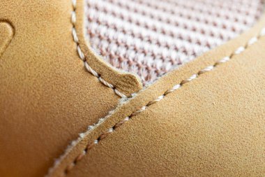 Kaliteli bir ayakkabının yakın plan görüntüsü. Bronz deriye detaylı dikişler atılmış.