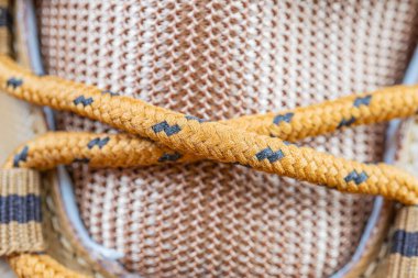 Çevre dostu, doğal jüt bağcıklı, kahverengi tonları olan ayakkabıların yakın görüntüsü.