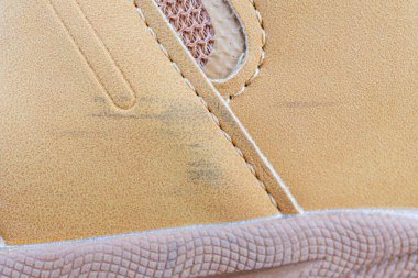 Dokulu süet detaylı, dantelli ve dayanıklı dış tabanlı sıradan bir spor ayakkabısının yakın plan görüntüsü