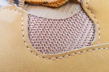 Ayakkabı boyama işçiliğinin yakın plan resmi, düzgün dikişler ve pazarlamada dayanıklılık ve detaylara dikkat için kullanılan yüksek kaliteli malzemeler