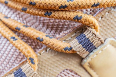 Kahverengi ve siyah tonlarda uzun ömürlü, yüksek kalitede örülmüş bir kayışın yakın plan görüntüsü, çanta veya ayakkabı gibi engebeli kullanım ürünleri için uygundur. Maceracılar, gezginler ve sağlam bir giriş arayanlar için cazip gelir.