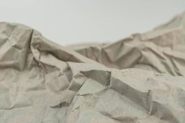 Buruşmuş kağıdın yakın plan görüntüsü, topoğrafik haritaları veya dağlık arazileri andıran görüntüler. Karmaşık kıvrımlar ve kırışıklıklar üzerinde duruluyor, karmaşıklık ve derinliği gösteriyor.
