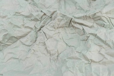 Çevresel bilinç, sürdürülebilirlik veya klasik kalite gibi temalar için dokunsal niteliklerin vurgulandığı, buruşmuş yeşilimsi kağıdın yakın plan görüntüsü