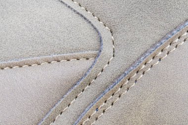 Karmaşık bir şekilde dikilmiş kumaşın yakın plan görüntüsü, gösterişli esnek dikişler ve kaliteli işçiliğin vurgulanması