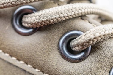 Ayakkabı bağcıklama mekanizmasının yakın plan görüntüsü, göz ve metalik bakımı vurguluyor. Ayrıntılar bağcıkların dokusunu ve desenli tasarımı da içeriyor. Bu da senin için dayanıklı bir işçilik olduğunu gösteriyor.