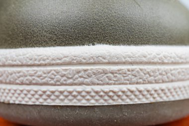 Beyaz, gri ve siyah bir renk eğimine sahip desenli, kavrayıcı kauçuk tabanlı engebeli bir açık hava ayakkabısı.