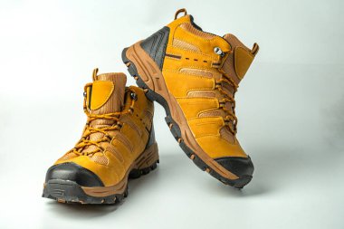 Resim, tarafsız bir arkaplanda yürüyüş botlarını gösterir, macerayı ve dayanıklılığı sembolize eder