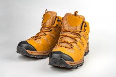 Görüntü, uzun ömürlü ve dantelli çizmeleri engebeli araziler için uygun olarak gösterir. Botların tutuş tabanları üzerinde çekiş desenleri ve topraksı bir renk düzeni vardır.