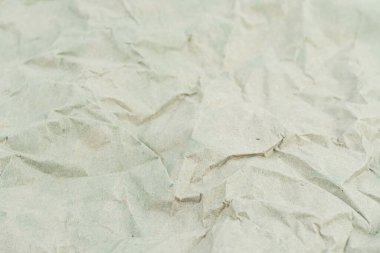 Resim, geri dönüşümü, sürdürülebilirliği, çevre dostu ambalajı, atık dönüşümünü ve dokunsal deneyimi sembolize eden buruşmuş kağıtların yakın çekimini tasvir ediyor