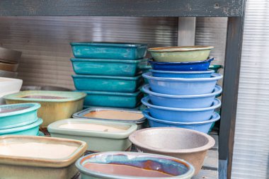 Raflara istiflenmiş el yapımı seramik, ince dokuları ile topraksı tonlarını sergiliyor. Mutfak eşyaları veya dekoratif amaçlar için uygun Rustik ama rafine görünüm, sanatsal stil ve çağrışımlar sunuyor.