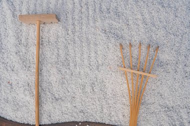 Görüntü bir süpürge ve faraş ile bölünmüş bir ekran gösteriyor, her ikisi de kapalı alan temizliği için doğal ahşap araçlar, dokulu bir duvara karşı.