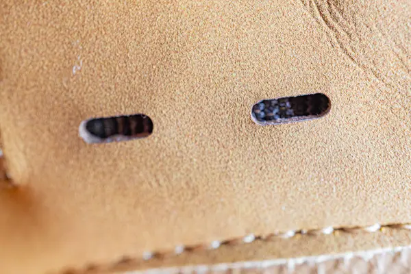 Yüksek kaliteli deri düğme deliklerinin yakın plan görüntüsü, mükemmel bir işçilik sergiliyor.