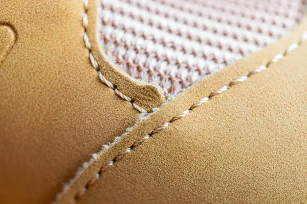 Kaliteli bir ayakkabının yakın plan görüntüsü. Bronz deriye detaylı dikişler atılmış.