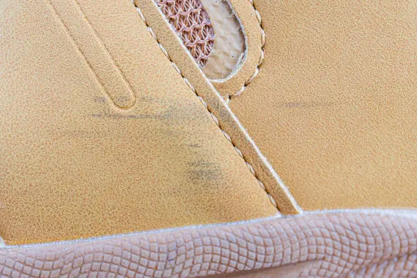 Dokulu süet detaylı, dantelli ve dayanıklı dış tabanlı sıradan bir spor ayakkabısının yakın plan görüntüsü