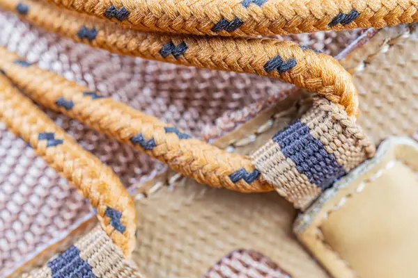 Kahverengi ve siyah tonlarda uzun ömürlü, yüksek kalitede örülmüş bir kayışın yakın plan görüntüsü, çanta veya ayakkabı gibi engebeli kullanım ürünleri için uygundur. Maceracılar, gezginler ve sağlam bir giriş arayanlar için cazip gelir.