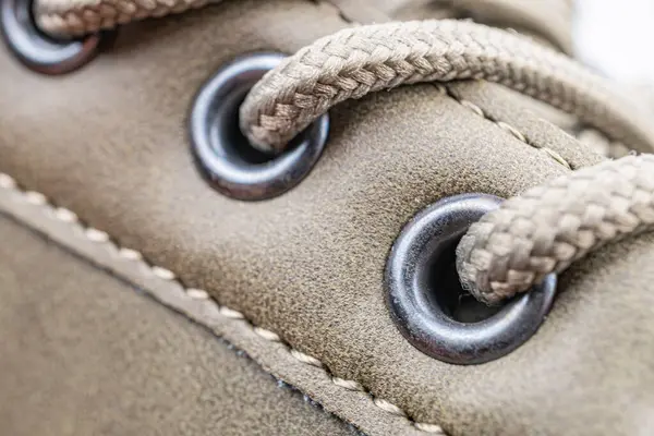 Görüntü iyi korunmuş kahverengi deri bir ayakkabı sunuyor. Gümüş metal gözlüklü, dayanıklılık ve zanaatkarlık gösteren.