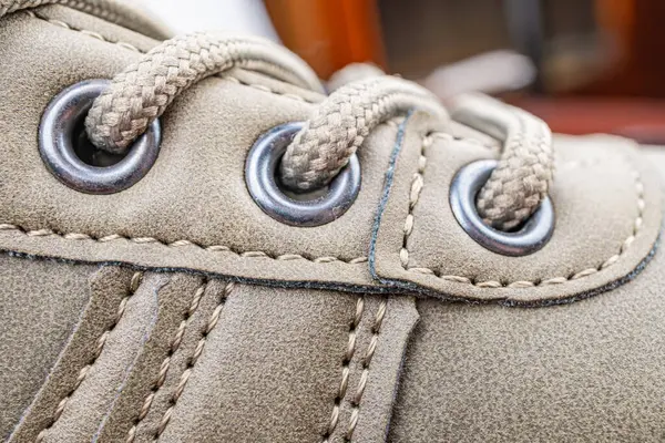 Ayakkabı danteli alanının yakından çekimi bağcıklar, göz eletleri ve dikişli aksanlar gibi ayrıntıları gösteriyor. Ayakkabı pazarlama için zanaatkarlığı vurguluyor.