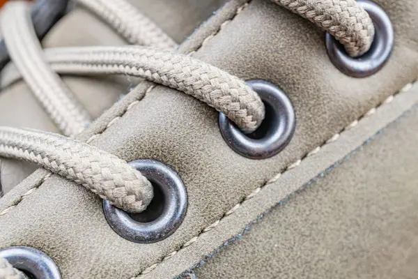 Dayanıklı, muhtemelen su geçirmez bir ayakkabının yakın plan fotoğrafı dayanıklı bağlama sistemi ve metal gözbebekleri, açık hava aktiviteleri veya sert koşullar için uygun