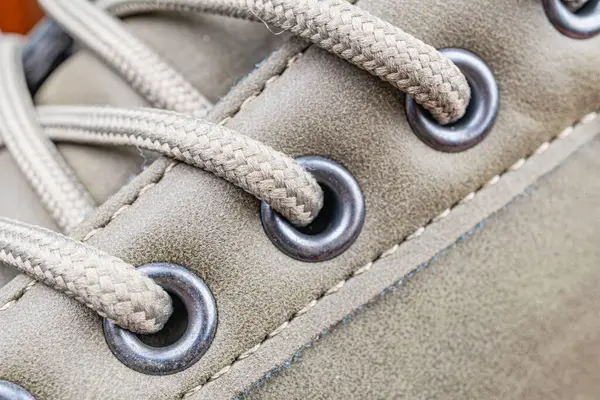 Yuvarlak ayak parmaklı bir ayakkabı, metal göz bilekliği ve açık hava aktiviteleri için dayanıklı bir yapı.