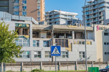 Görüntü, çok katlı bir binanın inşaatı veya yıkımının olduğu kentsel bir ortam gösteriyor, arka planda zıt yerleşim alanları, güvenlik önlemleri ve sessiz kolo Kyiv, Ukrayna 06-11-2024