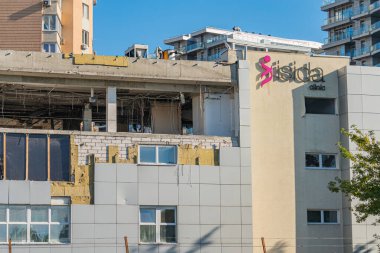Büyük camlı ve ön cephesinde pembe SADA tabelası bulunan mimari tarzların bir karışımı olan inşaat veya yenileme binası altında renk paleti baskın Kyiv, Ukrayna 06-11-2024