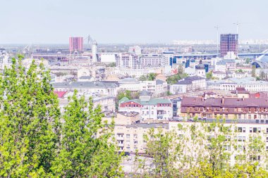 Düz ve eğimli çatıları, balkon ve terasları olan yerleşim alanları, Kyiv, Ukrayna 06-11-2024 ön cephesinde yemyeşil bir alan, modern ve geleneksel mimarisi ile canlı bir şehir.