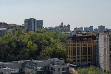 Modern cam cephelerinden geleneksel yapılara kadar mimari tarzların karışımına sahip yoğun, çeşitli bir şehir manzarası. Şehir çevresi hareketli, balkonlarla dolu, pi Kyiv, Ukrayna 06-11-2024