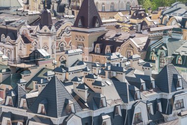 Görüntü, geleneksel mimariye sahip yoğun ve tarihi bir Avrupa kentsel manzarasını gösteriyor, konut ve ticari yapıların karışımının yer aldığı binalar çatıları Kyiv, Ukrayna 06-11-2024