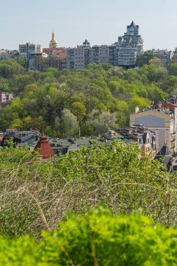 Tarihi bir şehir manzarasının kuş bakışı görüntüsü, çeşitli dönemlerden ve stillerden elementlerle mimari çeşitliliği sergiliyor. Merkezi dekoratif yapı ipuçları, muhtemel Kyiv, Ukrayna 06-11-2024