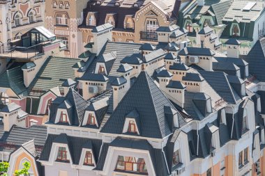 Çeşit çeşit mimari tarzlara sahip binaların bir koleksiyonu, çatılar ve yatakhane pencereleri ön planda, ön cephelerdeki pencereler ise Sid Kyiv, Ukrayna 06-11-2024