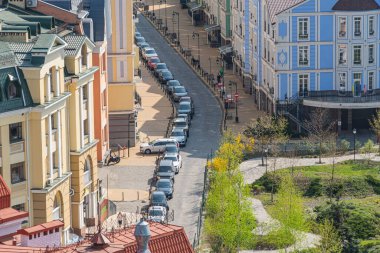 Çekici mimarisi, kaldırım taşı caddesi, parkı ve tarihle çelişen park edilmiş arabalarla dolu canlı bir Avrupa manzarası. Temiz mavi gökyüzü Kyiv 'i tamamlıyor, Ukrayna 06-11-2024