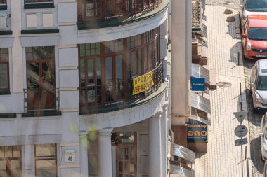 Resim, neoklasik ve iyonik mimari öğelerin yer aldığı klasik bir sokak sahnesini gösteriyor. Sol binada yarı dairesel kemerli pencereler, Fransız d Kyiv, Ukrayna 06-11-2024