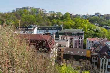 Resim, çeşitli mimari tarzlara ve dönemlere sahip tarihi bir Avrupa şehir manzarasını resmediyor, yoğun kentsel yapıda kırmızı tuğla ve taş binalar sergiliyor. Dikkat çekici özellikler i Kyiv, Ukrayna 06-11-2024