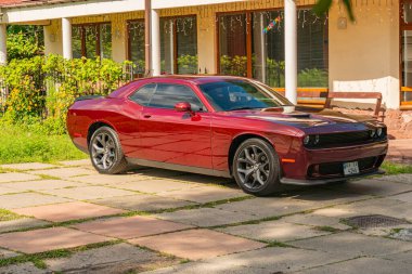 20. yüzyılın ortalarından kalma Kyiv, Ukrayna 06-11-2024 'e ait bir kaldırımda duran kırmızı Dodge Challenger' ın özel tasarım ve kaslı detaylarını gösteren yakın plan bir fotoğrafı.